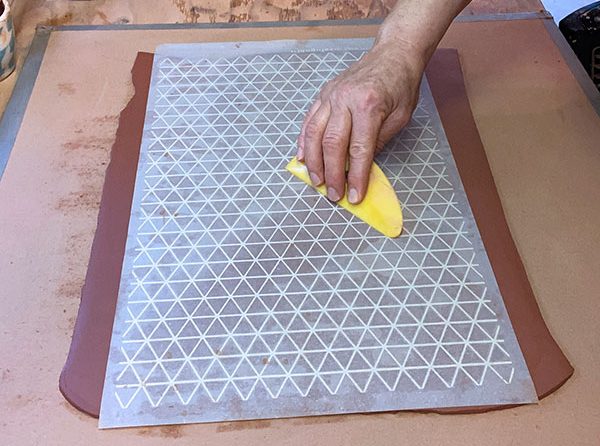 1 Apply the newsprint transfer to the slab. Compress with ribs to transfer fully.