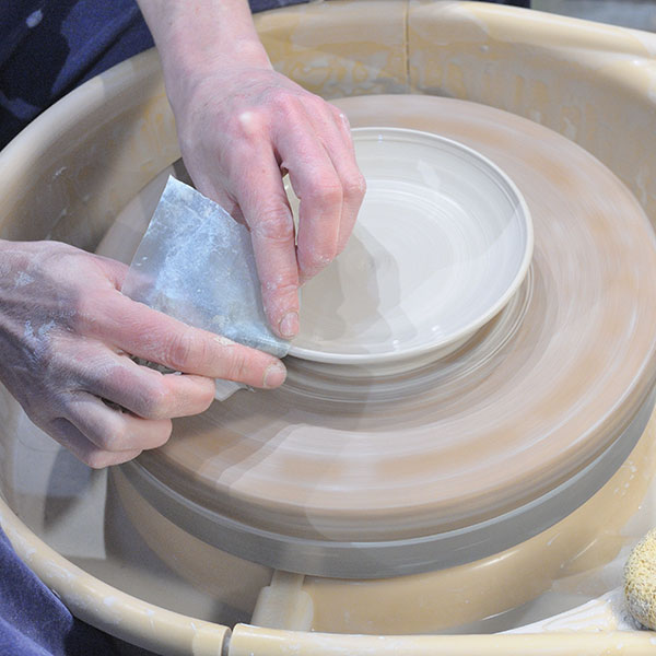 2 Compress and remove excess slip from the rim of the plate using a plastic bag.