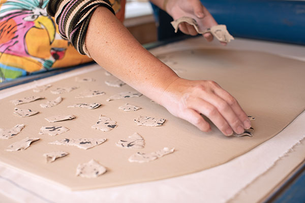5 Roll out your base clay, tear colored-clay slabs, and place them onto the base slab.