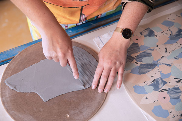 8 Cut strips of chocolate-brown porcelain and lay them across the colored slab.