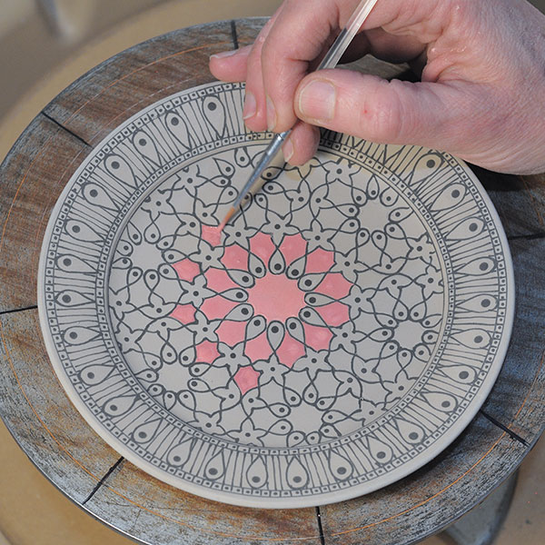 10 Paint a gradation of red underglaze between the lines using a fine liner brush.