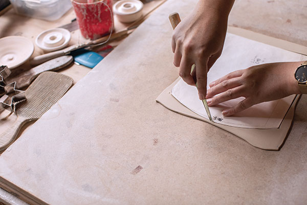 10 Cut around the template, bevel the ends, score the rounded side, then apply slip.