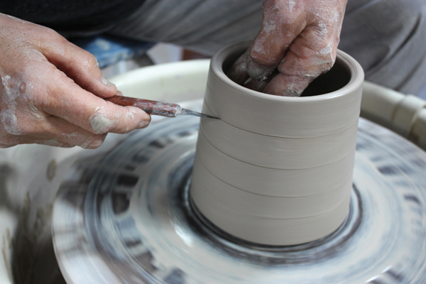 1 Throw a cylinder, support it from the inside, and use a sharp knife to slice the surface, but not all the way through.