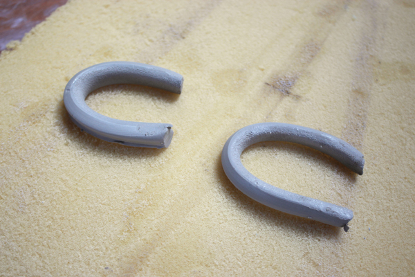 9 Roll two small coils for the handle loops. Tap and shape them into the desired thickness, then allow them to set up.