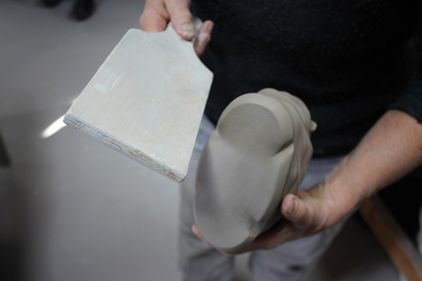 10 Hold the basket firmly and use a wooden paddle to strike the bottom edge of the pot to create sharp, angular dents.