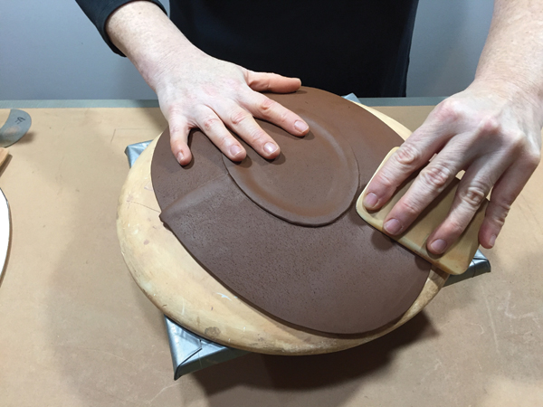 8 Compress the plate face onto the mold to help eliminate warping during the firing.