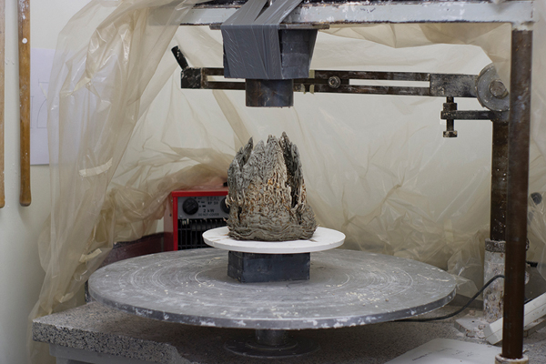 2 The vessels are shaped on a banding wheel set up under a strong magnet. The clay is built up using a syringe to extrude the slip into coils.
