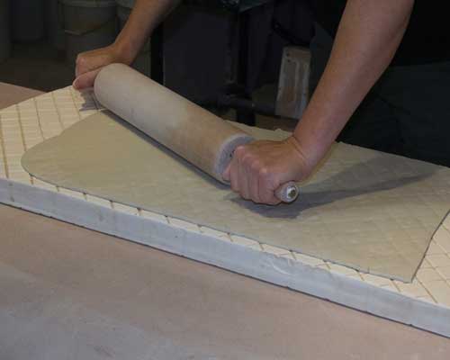 3 Use your hands, a rolling pin, and a rib, to work the clay into the slab’s texture.