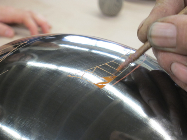 11 Once the outline is brushed on, a shorter brush is used to fill in larger areas with color.