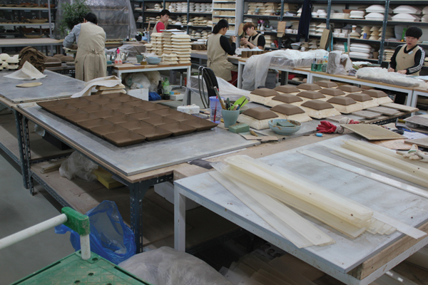4 Several of the 120 employees at Yido Ceramics working in the open plan studio. While we were visiting, they were using hump molds to make squared bowls for one of the company's various lines of dinnerware.