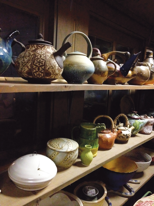 3 Shelves full of pots in Holland’s office (the teapot room), Forrest Lesch-Middelton’s teapot in the foreground, top shelf, Sandy Simon’s lidded container in the foreground, middle shelf.