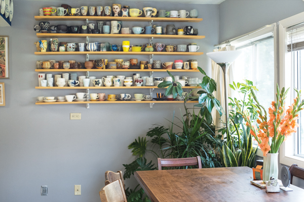 3 Cup shelves located within easy reach and pots in use on the kitchen table. Photo: Sarah Moore.