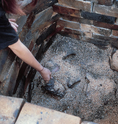 Removing the cooled work a few hours after the four to six hour firing is finished. The darkened work can now be cleaned and waxed.