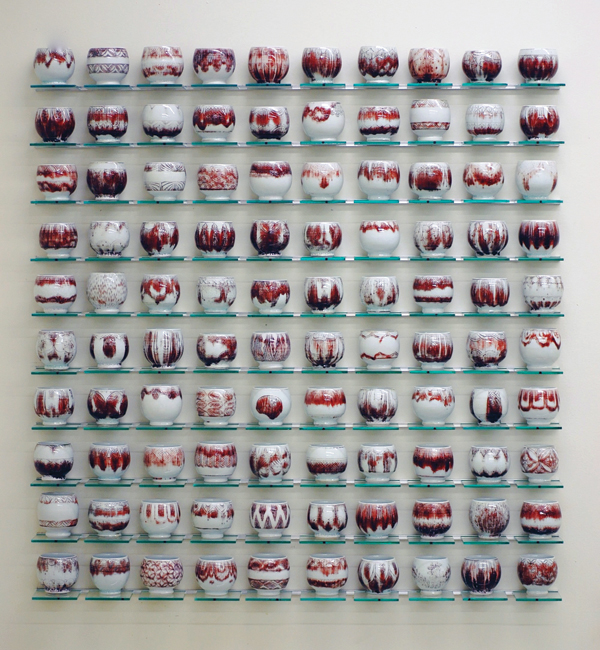 12 Steven Young Lee’s Red, Blue and White (detail of red cups), 50 in. (1.27 m) in height, porcelain, copper inlay, cobalt inlay, white slip, glaze, glass shelving, aluminum, 2013.