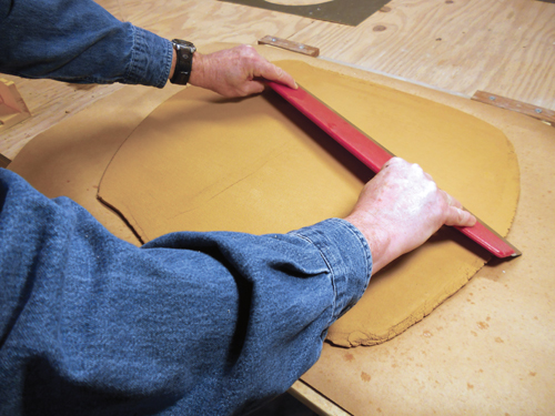 Step 1. Roll out a slab of clay on construction paper just under ½ inch thick. Spray water on the surface and smooth it.