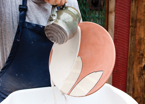 9 Hold the plate upright over a wide bucket and pour slip across the surface of the plate.