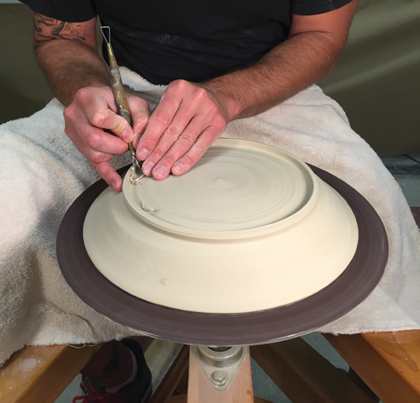 4 When the clay is leather hard, flip it upside down. Use a small trimming tool to remove excess clay, leaving a -inch-thick plate.