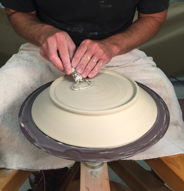 5 Use a large, flat trimming tool to remove trimming marks to create a smooth underside to the plate.
