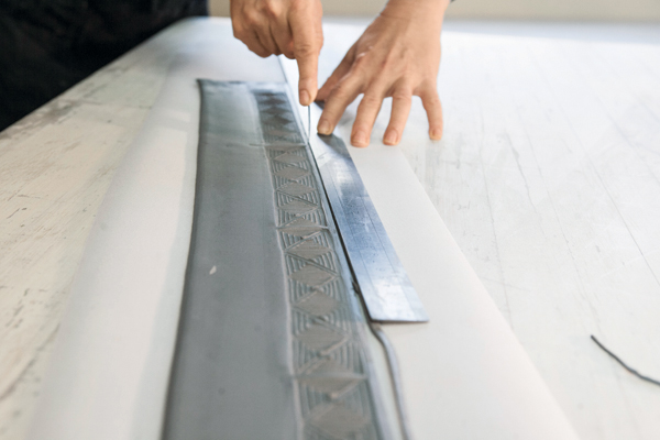 4 Cut a straight line under the stamped area along the length of the texture.