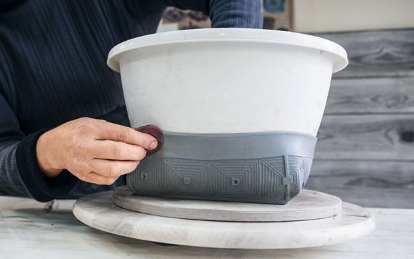21 Use a round plastic bowl to shape the bowl and smooth the rim.