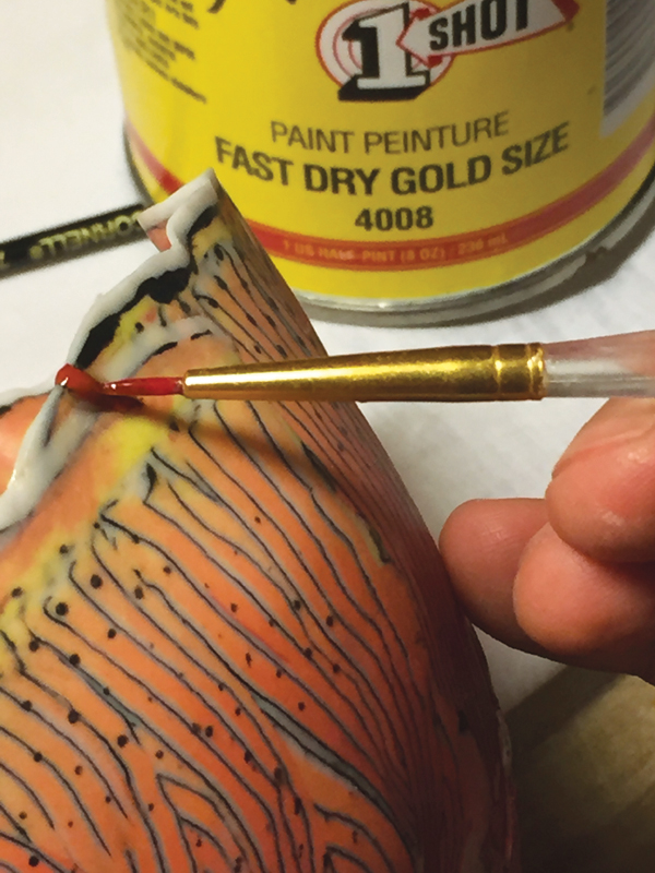 4 Brush on quick-set gold-leaf size (glue) to the epoxied area. Let dry for 30 minutes.
