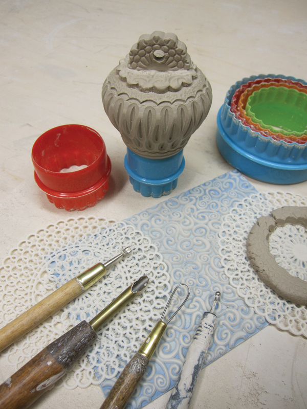 7 To finish the top, cut out pieces of a textured slab with a cookie cutter and attach them by scoring and slipping.