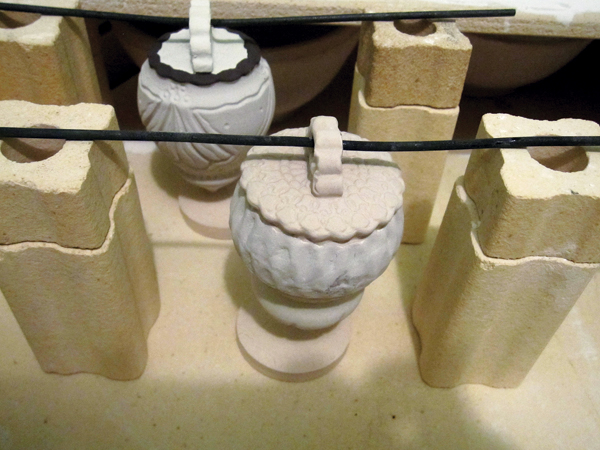 9 I hang my ornaments on high-temperature bead wire balanced between kiln posts. I place a piece of scrap clay underneath each ornament to catch any glaze drips.