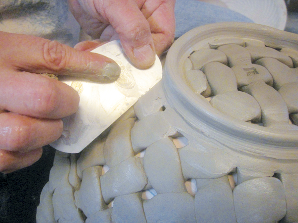 10 After smoothing the foot ring with a sponge, finish and define the foot edge with a metal rib.