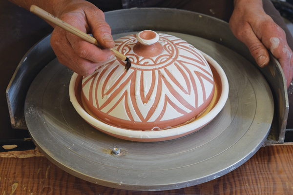 14 Remove glaze drips from the wax resist with a damp brush. Shave down any extra thick drips of glaze with a blade.