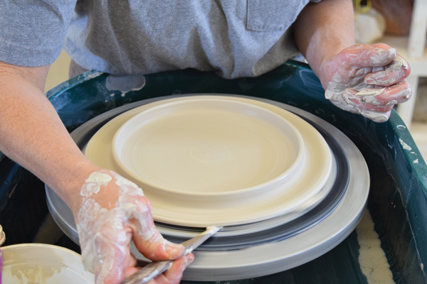 2 Push the pointed end of a wooden knife tool under the edge of the plate to lift it.