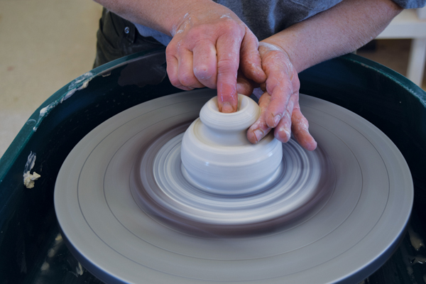 1 Center 2 pounds of clay and create a small knob at the top of the hump. Open up for the spout, then shape it.