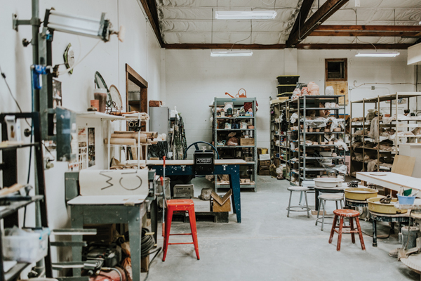 A view of the Wedge studio showing the extruder, &nbsp;slab rollers, some of the wheels, and pots in progress filling the numerous shelves